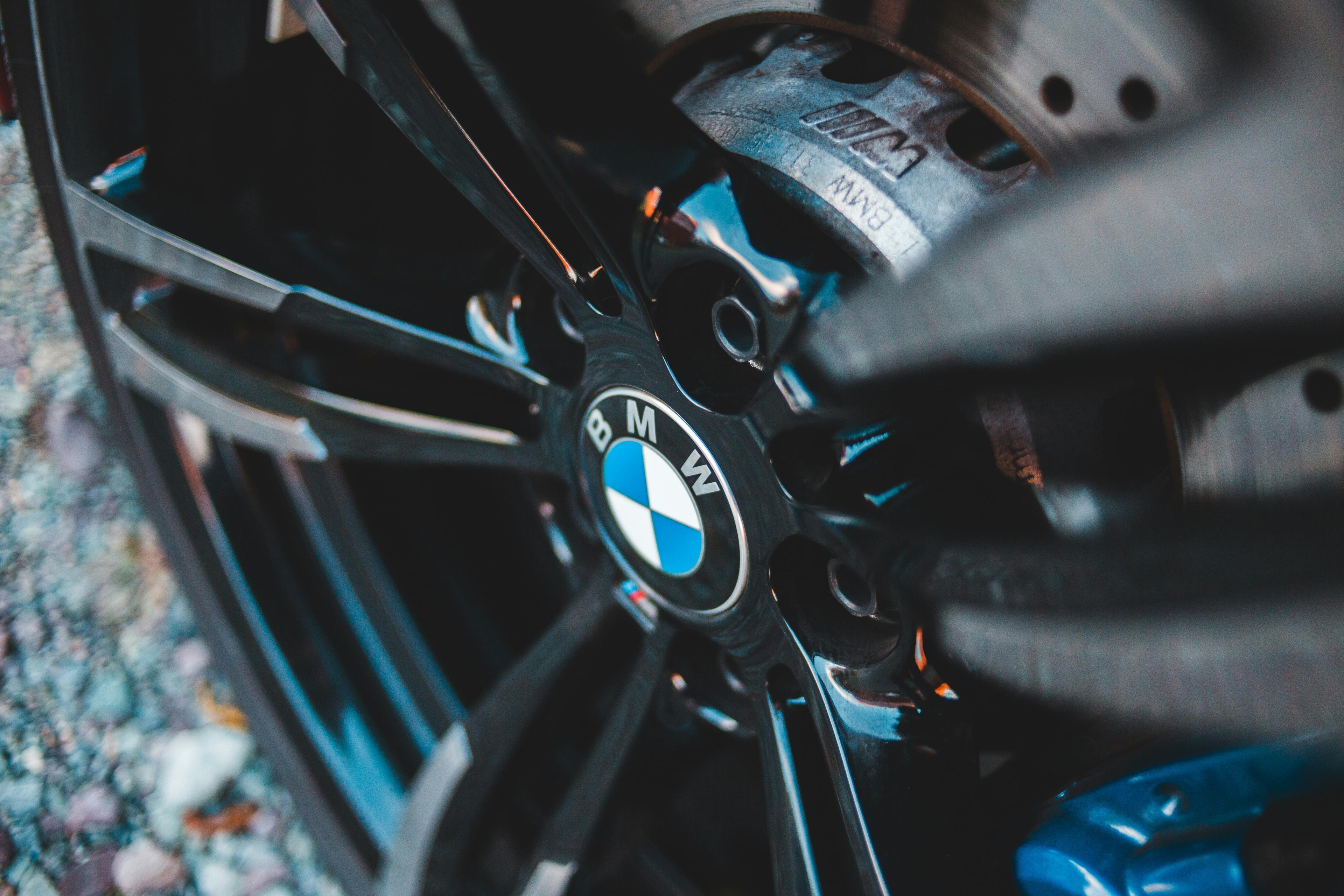 Gros plan sur la jante noire et le logo BMW d'une voiture avec frein perforé visible